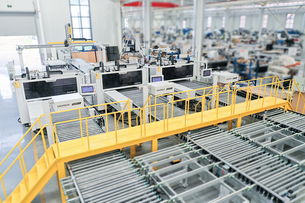 Célula de perfuração EXCITECH - solução de perfuração automática inteligente. Não limitada pela mão de obra, produção em vários turnos, requer menos operadores do que manuais, aumenta a produtividade